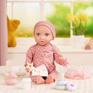 Babypuppe mit Schnuller im Pyjama mit Herzchen und Mütze