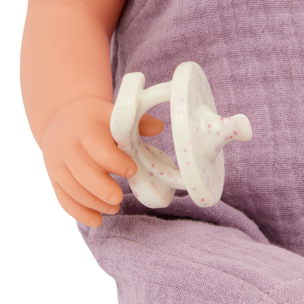 Babypuppe mit Schnuller im lila Musselinoutfit mit Stirnband