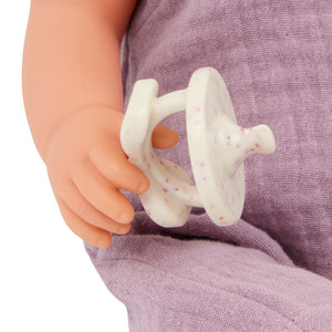 Babypuppe mit Schnuller im lila Musselinoutfit mit Stirnband