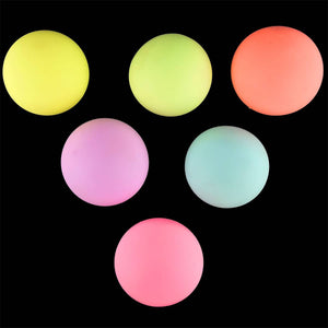 Neon-Knautschbälle in Gelb, Orange, Rosa und Blau leuchten im Dunkeln