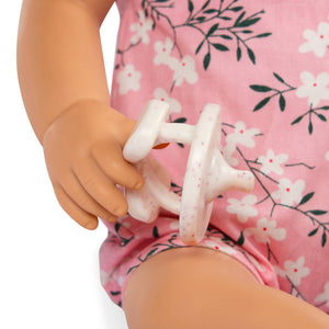 Babypuppe mit Schnuller – In rosa Kleidchen mit Blümchenmuster und Haarband