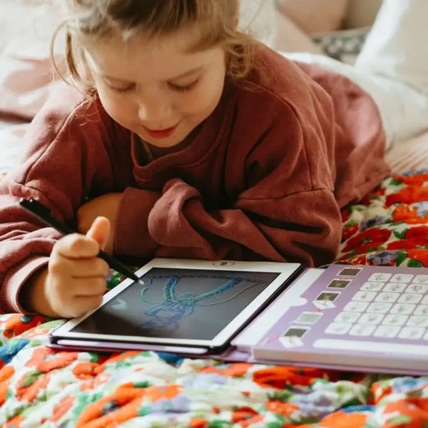 Grafiktablett Kidydraw Mini – Prinzessinnen in Benutzung von einem Kind auf einem bunten Bett