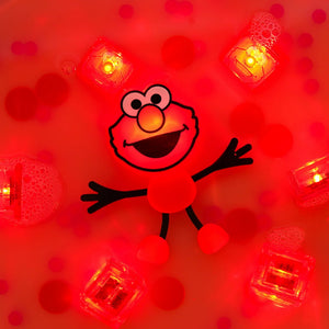 Badefigur Elmo – Set mit zwei im Wasser leuchtenden Sensorikwürfeln von Glo Pals im roten Badewasser