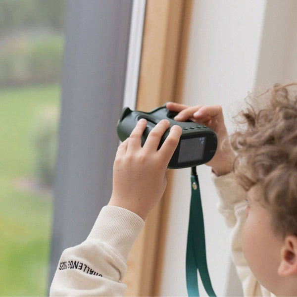 Ein Kind nutzt das Digitalmikroskop KidLupe, um Naturdetails durch das Fenster zu beobachten