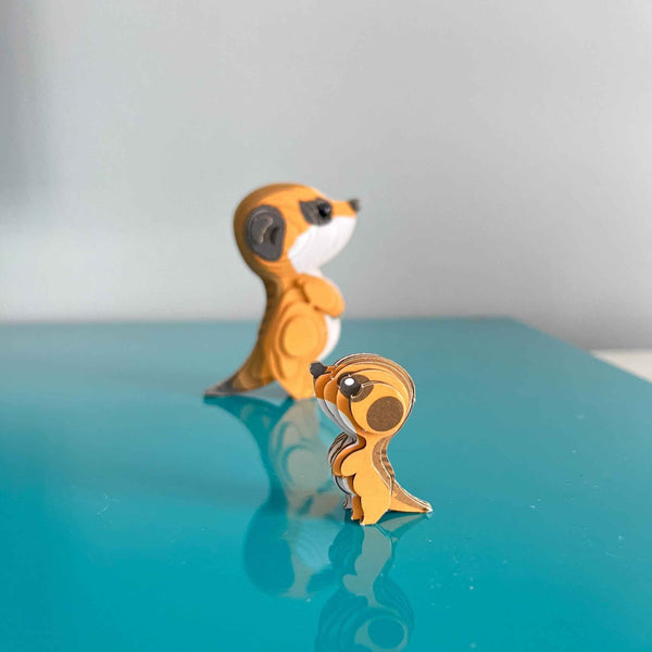 Eugy 3D Öko-Puzzle Erdmännchen mit zwei bunten Figuren auf einem blauen Tisch