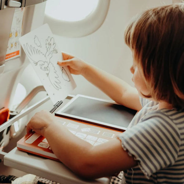 Kind malt mit Grafiktablett Kidydraw Mini – Tiere im Flugzeug auf einem Tisch