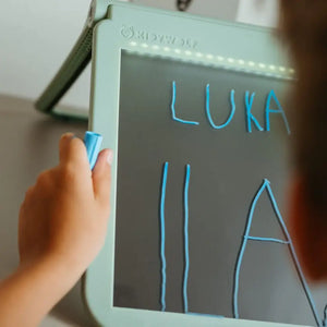 Kind benutzt die Leuchttafel Kidydraw Pro zum Schreiben und Zeichnen mit einem blauen Stift
