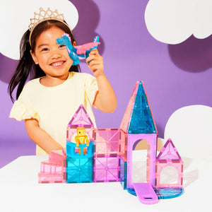 Mädchen mit MAGNA-TILES Magnetbausteine Burg Set spielt mit Figuren und Tier, fröhlich und kreativ.