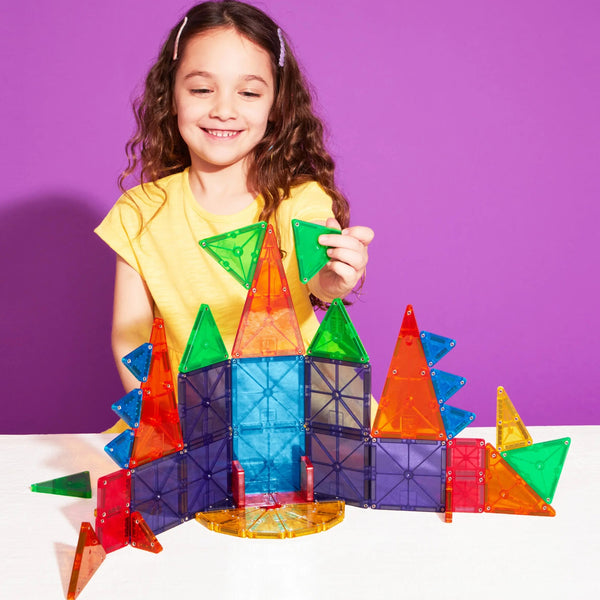 Eine glückliche Kinder mit MAGNA-TILES baut farbenfrohe Strukturen aus Magnetbausteinen Kinder