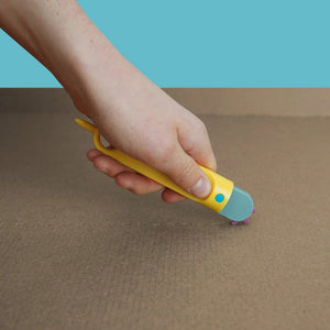 Makedo Sicherer Kartonperforierroller Fold-Roller in Gelb wird auf Karton verwendet