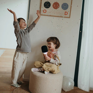 Kinder feiern mit einem Mikrofon mit Sprachmodulation in einem festlichen Raum