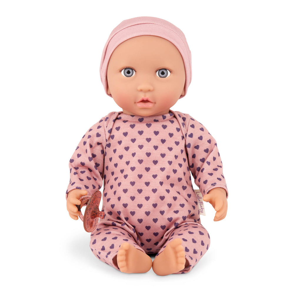 Babypuppe mit Schnuller im Pyjama mit lila Herzchen und Mütze
