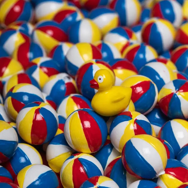 Bunte Sensorikflasche für Kinder mit einer gelben Gummiente und vielen bunten Bällen