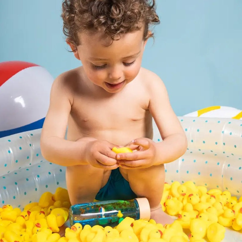 Sensorikflasche für Kinder mit bunten Schwimmspielzeugen und blauem Wasser für haptische Erkundung