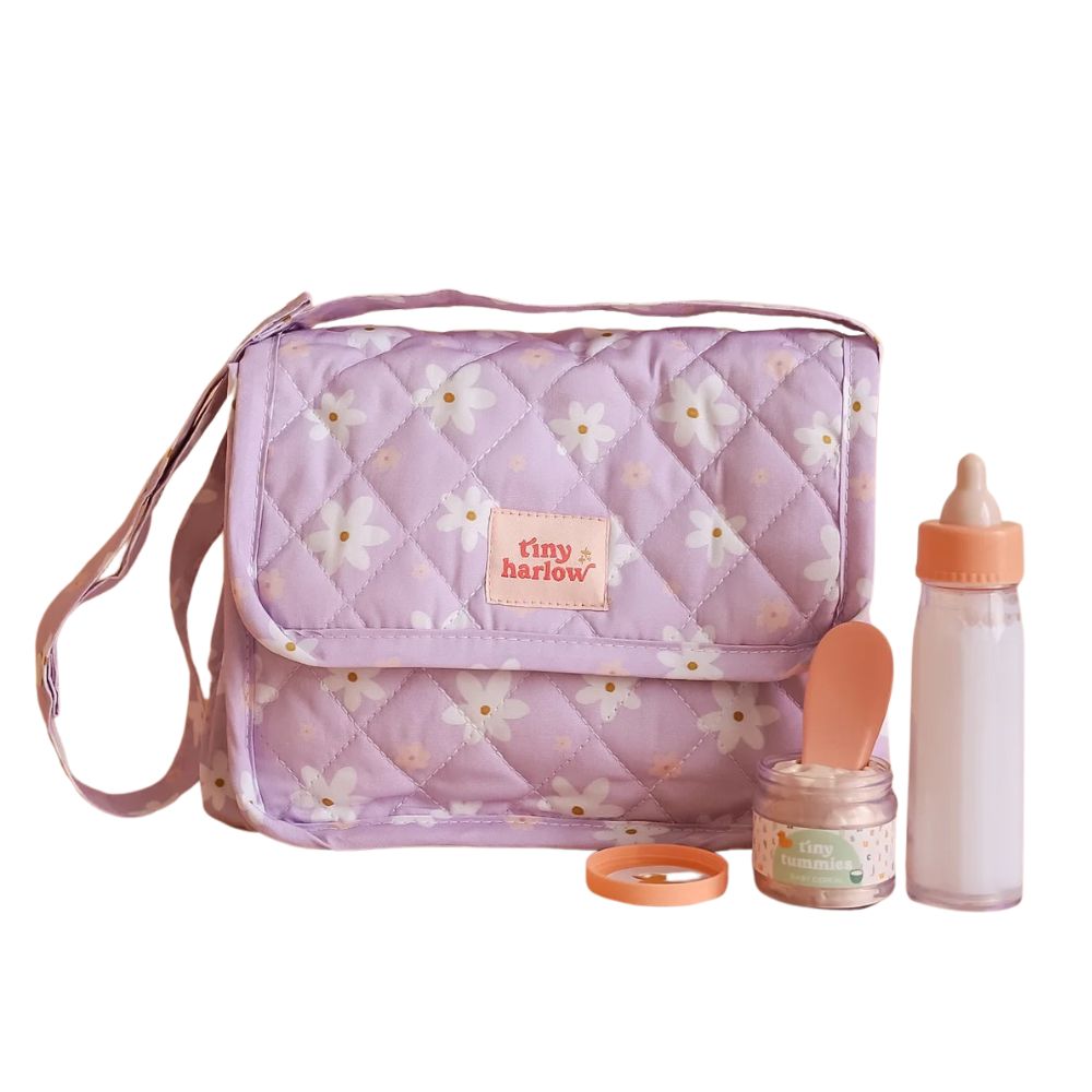 Tasche mit Zubehör für Puppen von Tiny Harlow, lila mit Blumenmuster, inklusive Flasche und Löffel.